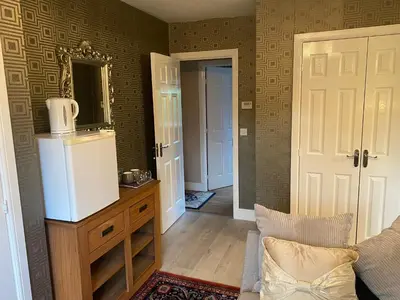 a living room with a refrigerator and a mirror at Doune Duck Ponds Accommodation in Doune