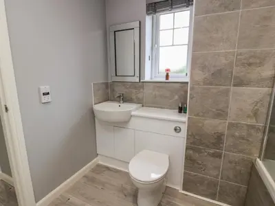 a bathroom with a toilet and a sink at The Dairy in Airdrie