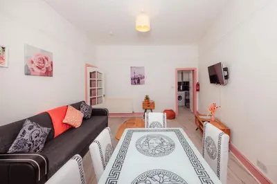 a living room with a couch and a table and chairs at Cosy Central Apartment by the Meadows 11 in Edinburgh