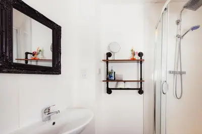 a bathroom with a sink and a mirror and a shower at Cosy Central Apartment by the Meadows 11 in Edinburgh