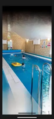 a swimming pool with two people in the water at Turnberry holiday park in Turnberry