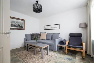 a living room with a couch and a table and a chair at Grassmarket Apartment in Edinburgh