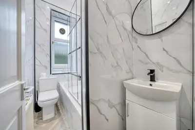 a bathroom with a sink and a toilet and a mirror at 3BR Flat Near Maryhill Park and West End with Parking in Partick
