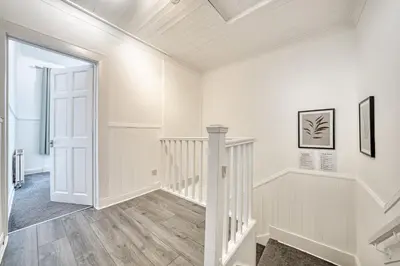 an empty hallway with white walls and a white stairway at 3BR Flat Near Maryhill Park and West End with Parking in Partick