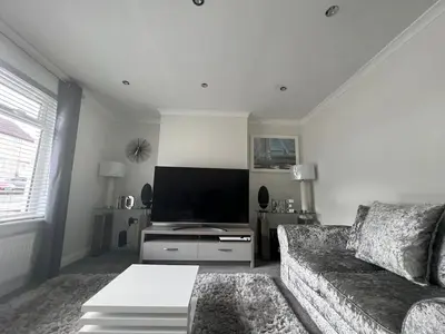 a living room with a couch and a flat screen tv at LUXERY 1 Bedroom Apartment - Falkirk in Falkirk