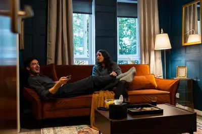 a man and woman sitting on a couch in a living room at Finnieston 1BR - Walk to Hydro & SEC - Parking in Glasgow