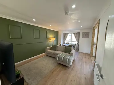 a living room with a couch and a television at Luxurious 2 bedroom, 8 mins from city centre in Glasgow