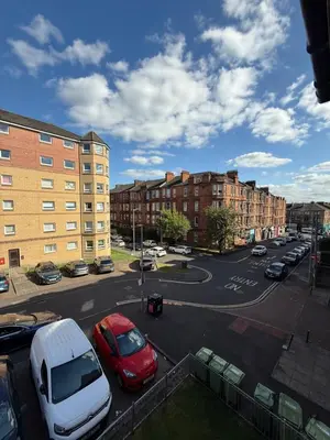 a street with cars parked in a parking lot at Luxurious 2 bedroom, 8 mins from city centre in Glasgow