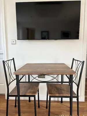a wooden table with two chairs and a mirror at Muirside Cottage in Stirling