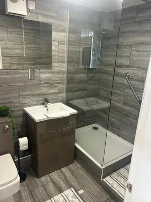 a bathroom with a shower and a sink and a toilet at Muirside Cottage in Stirling