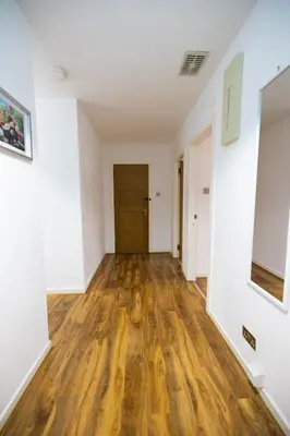 an empty room with wood floors and a door at Sauchihall Apartment in Glasgow