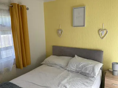 a bedroom with a bed with two hearts on the wall at Blackpool chalet - free parking in Moffat
