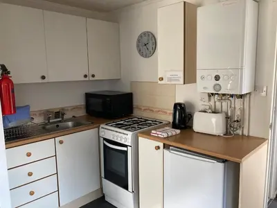 a small kitchen with a stove and a sink at Blackpool chalet - free parking in Moffat