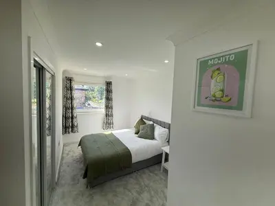a white bedroom with a bed and a window at Luxurious 2BR, 8 mins from centre in Glasgow