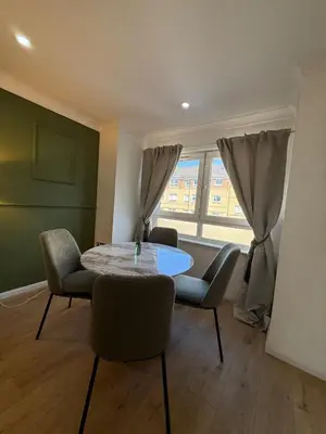 a room with a table and chairs and a window at Luxurious 2BR, 8 mins from centre in Glasgow