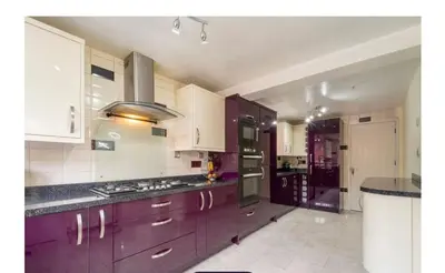 a kitchen with purple cabinets and a stove top oven at Modern 4-Bed Family Home in Solihull in Moffat