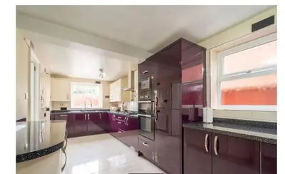 a large kitchen with purple cabinets and a window at Modern 4-Bed Family Home in Solihull in Moffat