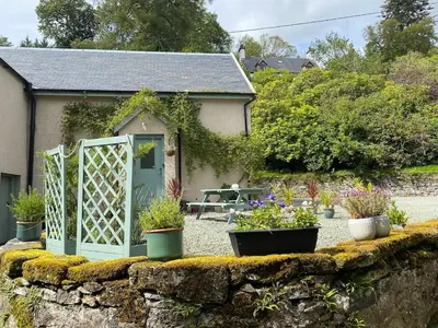 a garden with a gate and some potted plants at Allt-Na-Craig Coach House - Ardrishaig in Ardrishaig