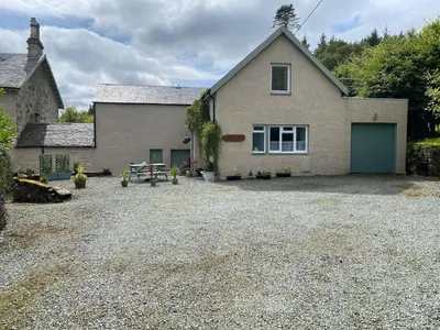 a house with a gravel driveway in front of it at Allt-Na-Craig Coach House - Ardrishaig in Ardrishaig