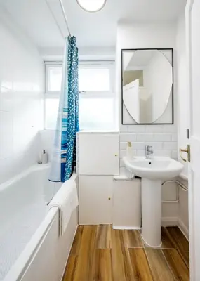 a bathroom with a sink and a tub and a mirror at Cozy 2 bedroom London Flat in Heart of Pimlico in Moffat