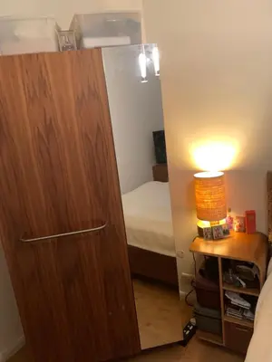 a large wooden cabinet in a bedroom with a bed at Elegant, Cozy 1 Bedroom Flat In Heart Of London Pimlico in Moffat