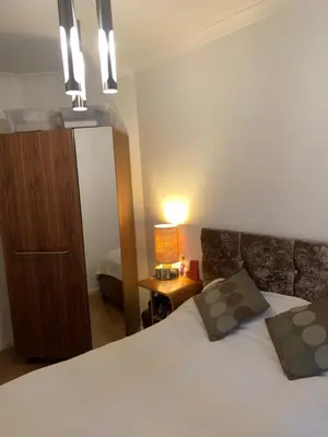 a bedroom with a bed and a dresser and a mirror at Elegant, Cozy 1 Bedroom Flat In Heart Of London Pimlico in Moffat