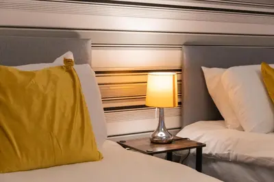 a bedroom with two beds and a lamp on a table at Buchanan Penthouse in Glasgow