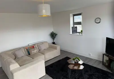 a living room with a couch and a tv at Buchanan Penthouse in Glasgow