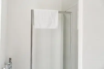 a shower stall with a white towel hanging on it at Buchanan Penthouse in Glasgow