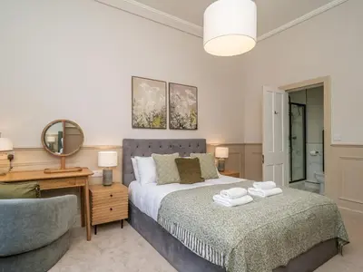 a bedroom with a bed and a chair and a mirror at Pass the Keys Beautiful Modern Historical Flat Close to Castle in Edinburgh