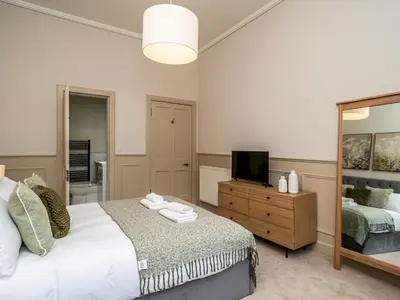 a bedroom with a bed and a mirror and a television at Pass the Keys Beautiful Modern Historical Flat Close to Castle in Edinburgh