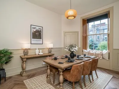 a dining room with a wooden table and chairs at Pass the Keys Beautiful Modern Historical Flat Close to Castle in Edinburgh