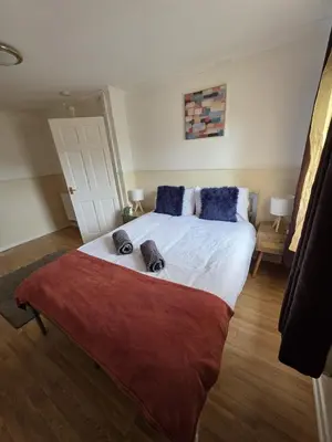 a bedroom with a large white bed with blue pillows at 3BR House with Parking 10 Mins to Airport Sleeps 6 in EDI