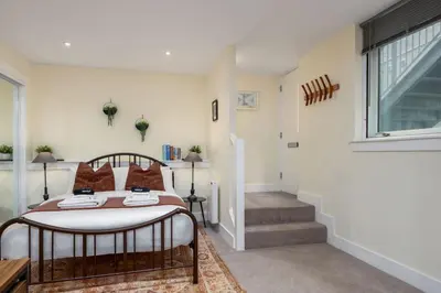 a bedroom with a bed and a window and stairs at Stirlings Hidden and Tranquil Studio Apartment in Stirling