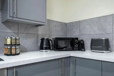 a kitchen counter with a microwave and a toaster oven at Stirlings Hidden and Tranquil Studio Apartment in Stirling