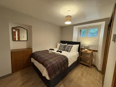 a bedroom with a bed and a mirror and a window at Watt-A-View in Limekilns