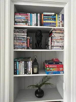 a book shelf filled with books and a potted plant at Sugar boat view in Greenock