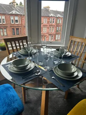 a table with plates and wine glasses on it at Sugar boat view in Greenock