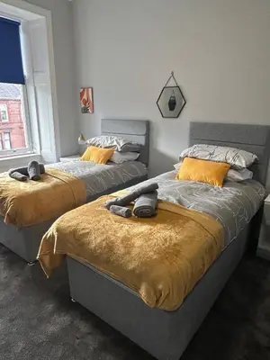 two beds sitting next to each other in a bedroom at Sugar boat view in Greenock