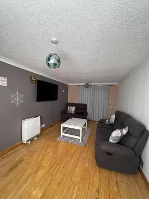 a living room with a couch and a tv at Honey House in Moffat