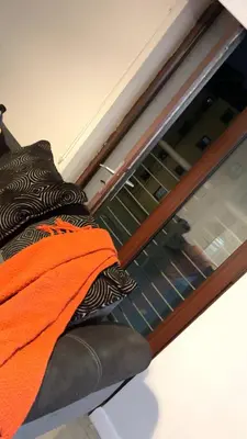 a glass window with an orange towel on a couch at The friendly place in Glasgow