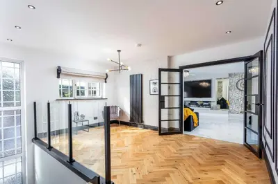 a living room with a wooden floor and a sliding glass door at No22 Shalloch House - Donnini Apartments in Ayr