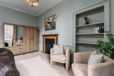 a living room with two chairs and a fireplace at The Allan Maisonette Charming Georgian Retreat in Stirling