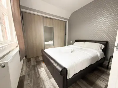 a bedroom with a large bed and a window at Glasgow Home Newly Refurbished in Glasgow