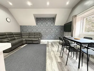 a living room with a couch and a table and chairs at Glasgow Home Newly Refurbished in Glasgow