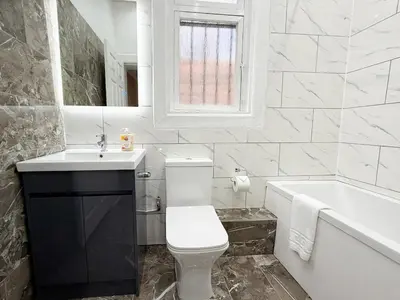 a bathroom with a toilet and a sink and a tub at Glasgow Home Newly Refurbished in Glasgow