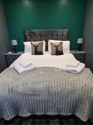 a bedroom with a large bed with two towels on it at The Post Office Tarbet in Tarbet