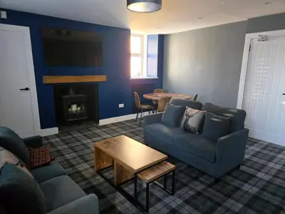 a living room with a couch and a table at The Post Office Tarbet in Tarbet