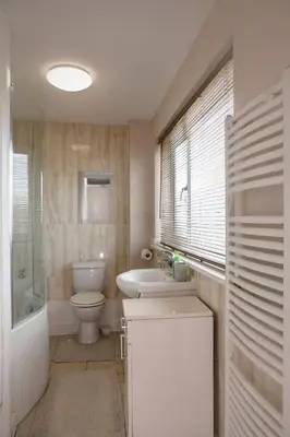 a bathroom with a toilet and a sink and a bath tub at 70 Abbotsbury Road, Bury St Edmunds, IP33 2HP in Moffat