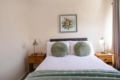 a bedroom with a bed with two pillows and two lamps at 70 Abbotsbury Road, Bury St Edmunds, IP33 2HP in Moffat